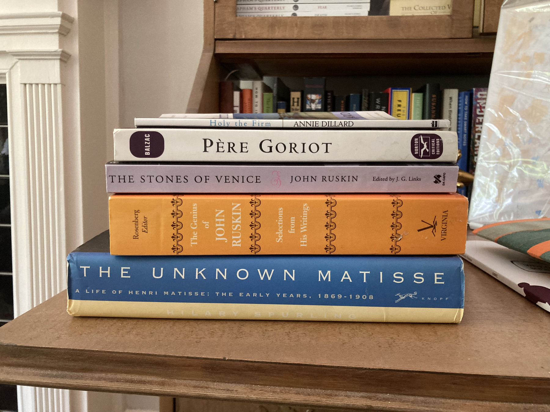 Books piled on a secretary desk.